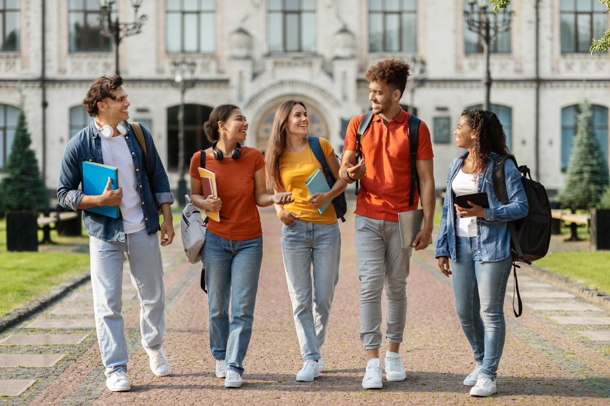 Group of happy multiethnic students walking together on campus