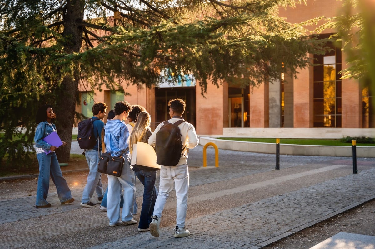 Group of diverse students walking together on a university campus